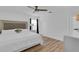 Bright bedroom features a ceiling fan, plush bedding, and wood-look flooring at 14287 E Weymouth Run, Orlando, FL 32828