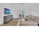 Spacious living room with vaulted ceilings, a ceiling fan, and access to the patio through glass doors at 14287 E Weymouth Run, Orlando, FL 32828