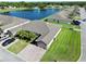 Stunning aerial view of a home with a long driveway, lush lawn, mature palms, and a peaceful pond at 1749 Christina Lee Ln, St Cloud, FL 34769
