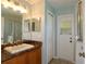 Bathroom with wood vanity, mirror, and shower with glass doors at 1749 Christina Lee Ln, St Cloud, FL 34769