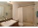 Bathroom with wood vanity, mirror, and bathtub with shower and shower curtain at 1749 Christina Lee Ln, St Cloud, FL 34769