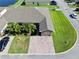 Aerial view of a well-maintained home with a brick driveway, lush lawn, mature palms, and a two-car garage at 1749 Christina Lee Ln, St Cloud, FL 34769