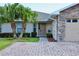 Charming home with desert landscaping, brick paver driveway, and a two-car garage with stone accents at 1749 Christina Lee Ln, St Cloud, FL 34769