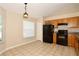Bright kitchen featuring tile floors, oak cabinets, and black appliances at 1749 Christina Lee Ln, St Cloud, FL 34769