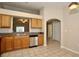 Kitchen area featuring tile floors, wood cabinets, a stainless-steel dishwasher, and a bar-style pass through at 1749 Christina Lee Ln, St Cloud, FL 34769