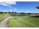 Scenic community pond view featuring a fountain, lush green lawns, and a walking path on a bright sunny day at 1749 Christina Lee Ln, St Cloud, FL 34769