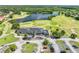 Aerial view of a golf course clubhouse with parking, and putting greens near a scenic lake at 1810 Lee Janzen Dr, Kissimmee, FL 34744