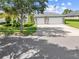 Charming home with well-manicured lawn, landscaping, a long driveway, and a two-car garage at 1810 Lee Janzen Dr, Kissimmee, FL 34744