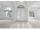 Bright foyer with tiled floors, arched windows, and a clear view of the front doors at 1810 Lee Janzen Dr, Kissimmee, FL 34744