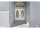 Close up of a white, double front door, with oval etched glass and stone tile entryway at 1810 Lee Janzen Dr, Kissimmee, FL 34744