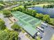 Aerial view of community tennis and basketball courts, playground, and RV parking near a scenic lake at 1810 Lee Janzen Dr, Kissimmee, FL 34744