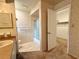 Bathroom with shower, vanity, and closet featuring earth-tone wallpaper and carpet at 1921 Japonica Rd, Winter Park, FL 32792