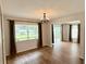 Elegant dining room with wood floors, chandelier, and natural light from large window and sliding glass door at 1921 Japonica Rd, Winter Park, FL 32792