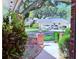 Inviting front yard view with brick features, lush greenery, and a glimpse of the charming home and driveway at 1921 Japonica Rd, Winter Park, FL 32792