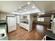 Open kitchen layout with wood floors, white cabinets, and view into the living room with fireplace at 1921 Japonica Rd, Winter Park, FL 32792