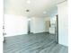 Open-concept living space with gray floors, leading to a white kitchen and providing a seamless flow at 2221 Wakulla Way, Orlando, FL 32839