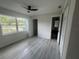 Bright bedroom with sleek gray floors, a ceiling fan, and a window view at 2549 Olive Ave, Lake Wales, FL 33898