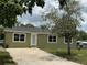 Charming home with an olive drab exterior, front yard, and concrete driveway leading up to the white front door at 2549 Olive Ave, Lake Wales, FL 33898