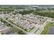 Expansive aerial view of a residential community, highlighting neatly arranged homes, green spaces, and a serene lake backdrop at 2740 Picasso Ct, Kissimmee, FL 34743