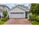 A two-story home with a brick driveway, blue front door, and a two-car garage at 2740 Picasso Ct, Kissimmee, FL 34743