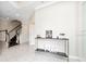 Bright foyer with decorative table, tile floors, staircase, and access to other rooms at 2740 Picasso Ct, Kissimmee, FL 34743
