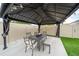 A cozy gazebo featuring an outdoor dining table and seating with ambient lighting, perfect for entertaining in the backyard at 2740 Picasso Ct, Kissimmee, FL 34743