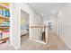Upstairs hallway features paneled walls, carpet flooring, and a view into a bedroom with a modern geometric wall design at 2740 Picasso Ct, Kissimmee, FL 34743
