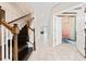 Hallway with white tiles, staircase, and an open door to a blue decorated room at 2740 Picasso Ct, Kissimmee, FL 34743