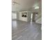 Bright, open-concept living room with wood-look flooring leading into the kitchen at 2833 Falling Tree Cir, Orlando, FL 32837