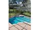 Aerial view of enclosed in-ground pool with hot tub and brick pavers at 2833 Falling Tree Cir, Orlando, FL 32837