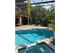 Relaxing screened-in pool area with brick patio, hot tub, and lush landscaping at 2833 Falling Tree Cir, Orlando, FL 32837