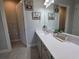 A bathroom with gray walls, a white vanity with a quartz countertop, a framed mirror, and a glass enclosed shower at 2853 Willowseed Ln, St Cloud, FL 34772