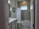 Well lit bathroom featuring a shower and bathtub combination with tiled surround, and a vanity with ample storage at 2853 Willowseed Ln, St Cloud, FL 34772