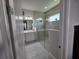 This bathroom features a large glass shower, gray tiled floors and walls, and a vanity with double sinks at 2853 Willowseed Ln, St Cloud, FL 34772
