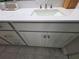 A close-up of the bathroom vanity with a white countertop, double sinks, and gray cabinets at 2853 Willowseed Ln, St Cloud, FL 34772