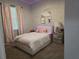 Charming bedroom with soft lighting, decorative wall art, and a cozy bed with pink accents at 2853 Willowseed Ln, St Cloud, FL 34772