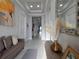 Inviting foyer with decorative mirror, elegant tray ceiling, and views of the hallway at 2853 Willowseed Ln, St Cloud, FL 34772