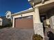 Close-up of a home's garage and front entryway with stacked stone accents and a paver driveway at 2853 Willowseed Ln, St Cloud, FL 34772