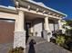 Close-up view of the front entryway featuring a covered porch with stone pillars and a paver walkway at 2853 Willowseed Ln, St Cloud, FL 34772