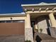Detailed view of a home's front exterior with a garage, stone accents, and a covered entryway at 2853 Willowseed Ln, St Cloud, FL 34772