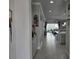 Bright hallway with tile flooring and neutral paint, leading to the open-concept living and dining area at 2853 Willowseed Ln, St Cloud, FL 34772