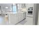 Bright and modern kitchen island featuring a quartz countertop, stainless steel sink, and seating for three at 2853 Willowseed Ln, St Cloud, FL 34772