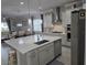 Open-concept kitchen featuring a quartz island, stainless steel appliances, and modern lighting fixtures at 2853 Willowseed Ln, St Cloud, FL 34772