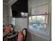 Living room with a wall mounted TV, window with white blinds, and a view of the patio at 2853 Willowseed Ln, St Cloud, FL 34772