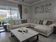 Cozy living room with a plush sectional sofa, decorative pillows, and a view to the screened patio at 2853 Willowseed Ln, St Cloud, FL 34772