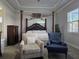 Spacious main bedroom featuring a tray ceiling, a four-poster bed, and comfortable seating at 2853 Willowseed Ln, St Cloud, FL 34772