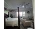 Bright main bedroom featuring tray ceilings, four-poster bed, and a view of the backyard at 2853 Willowseed Ln, St Cloud, FL 34772