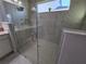 Close up of a large glass shower with a transom window, tiled walls, and chrome shower fixtures at 2853 Willowseed Ln, St Cloud, FL 34772