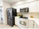 Efficient kitchen featuring stainless steel appliances, white countertops, and convenient washer/dryer access at 3006 S Semoran Blvd # H-3, Orlando, FL 32822