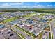 Aerial view of a vibrant community showcasing colorful homes, lush landscaping, and a serene lake at 3026 Prospect Trl, St Cloud, FL 34771